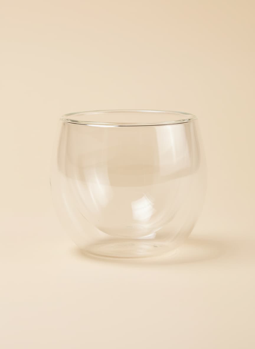A 250ml double-wall insulated glass cup with a rounded design on a white background.