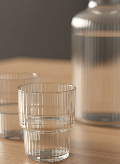 Close-up of the vertical rib texture on the crystal-clear glass carafe, ensuring a comfortable, non-slip grip.
