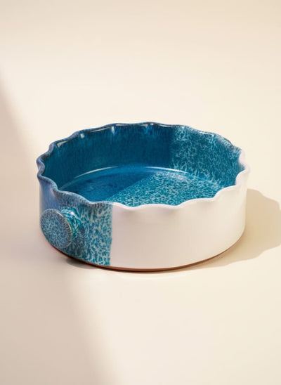 Round ceramic casserole dish with a beautiful ocean blue reactive glaze and scalloped rim.