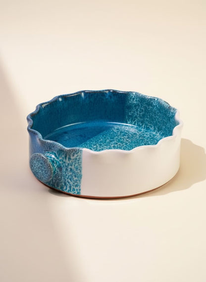 Round ceramic casserole dish with a beautiful ocean blue reactive glaze and scalloped rim.
