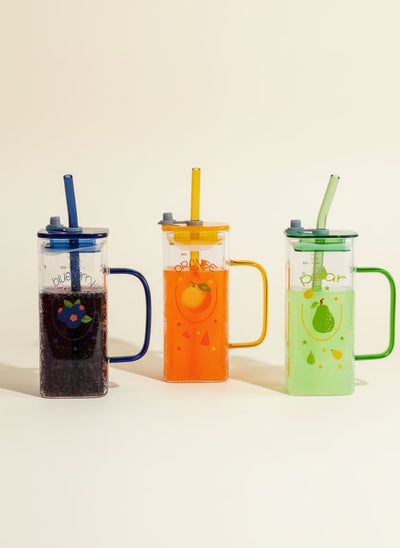 Set of three fruit-themed glass tumbler mugs with colorful lids, handles, and straws against a white background.