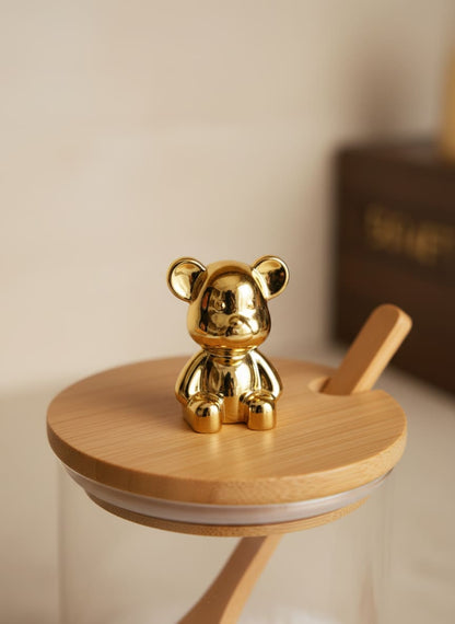 Close-up of a high-quality glass jar with a durable bamboo lid and a decorative, shiny golden bear knob.