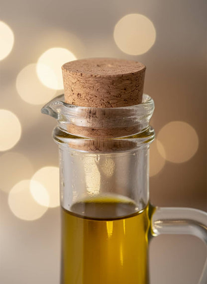 Close-up of the drip-free spout and secure cork stopper on the transparent glass oil cruet, showing its quality craftsmanship.