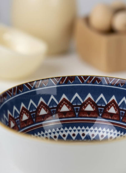Close-up of the smooth, glazed interior and durable gold rim on a bohemian-style porcelain bowl.