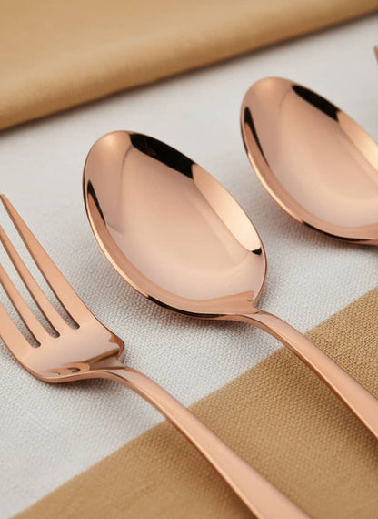 Close-up of the smooth, mirror-polished finish on the rose gold stainless steel spoons and forks.