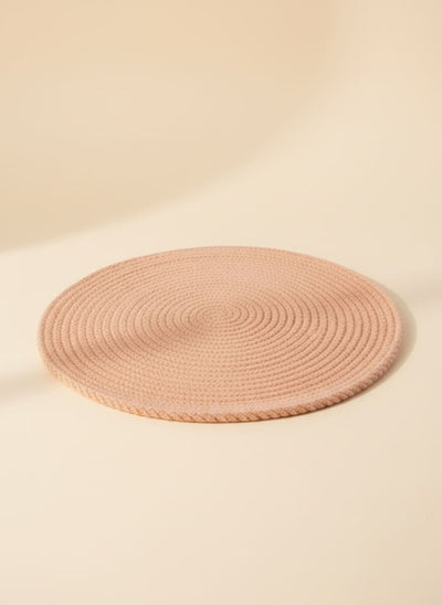 Round braided cotton placemat in a neutral camel color for dining table protection.