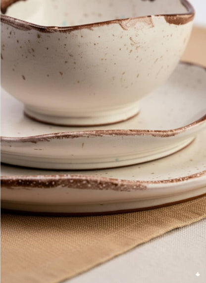 Close-up of the durable, textured brown rim on a cream speckled stoneware bowl.