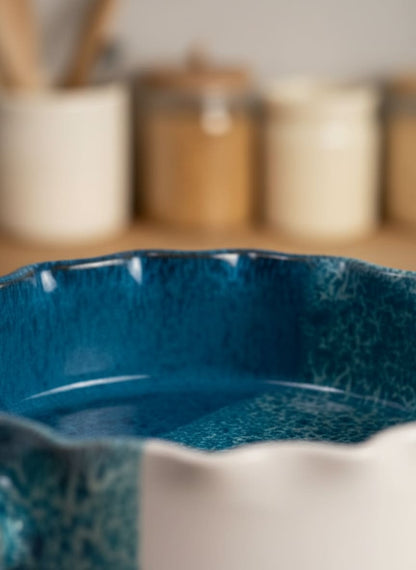 Close-up of the scalloped edge and textured side tab on the durable, easy-to-clean ceramic dish.