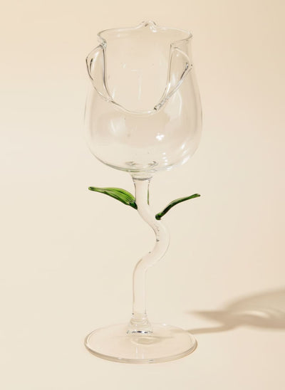 Elegant rose-shaped glass goblet with a green leaf stem design on a white background.