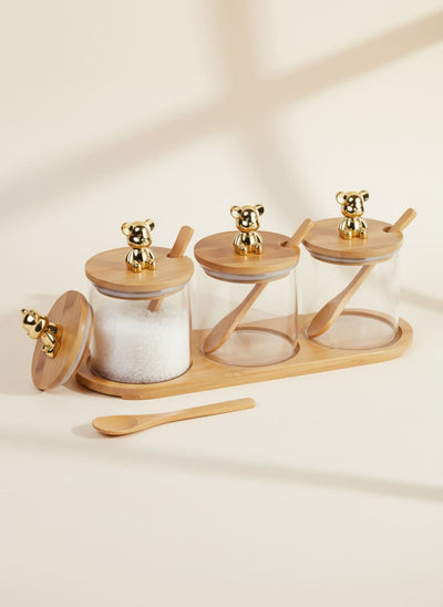 Set of three glass spice jars with bamboo lids featuring golden bear knobs, spoons, and a matching tray.